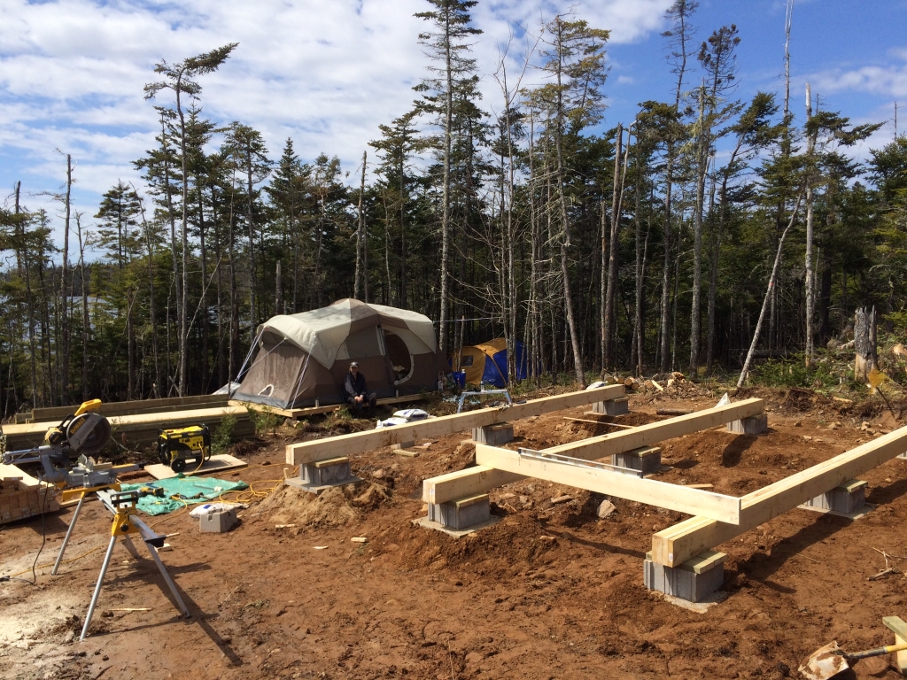 Laying out the beams for the off grid cabin foundation