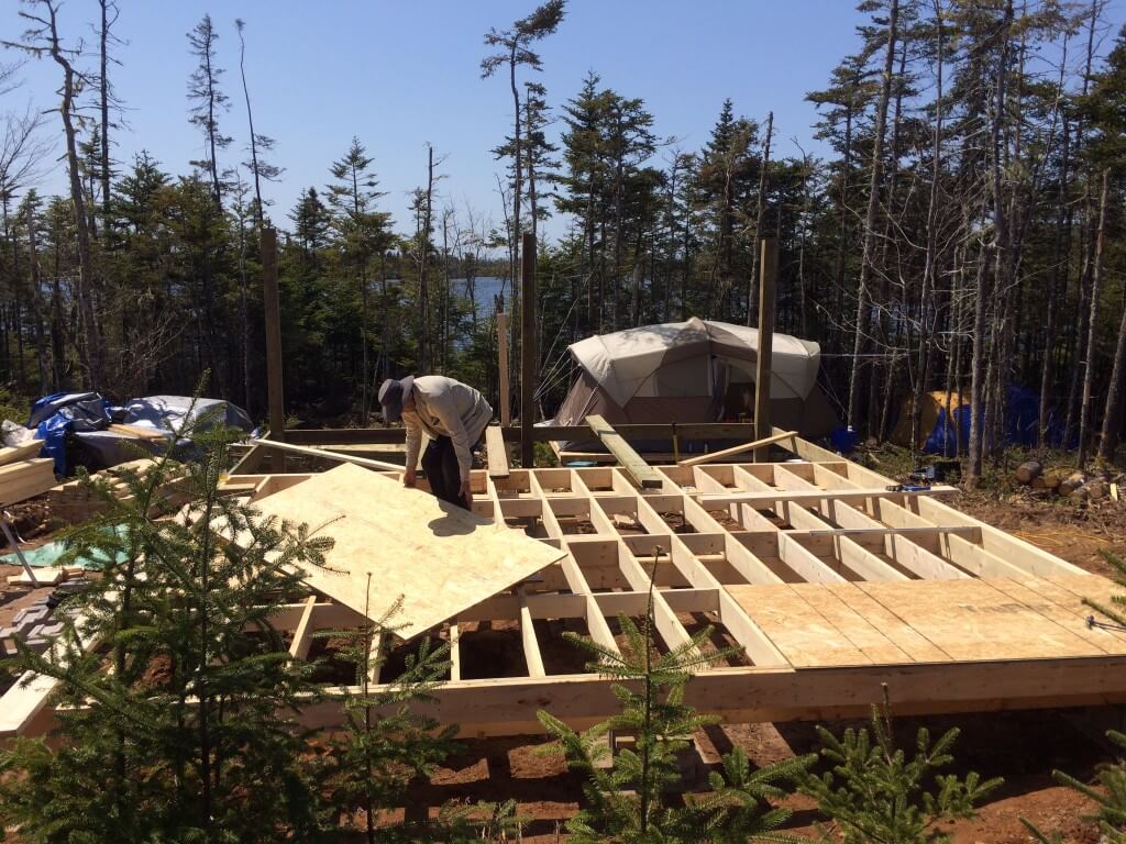 off grid cabin subfloor first sheets being installed