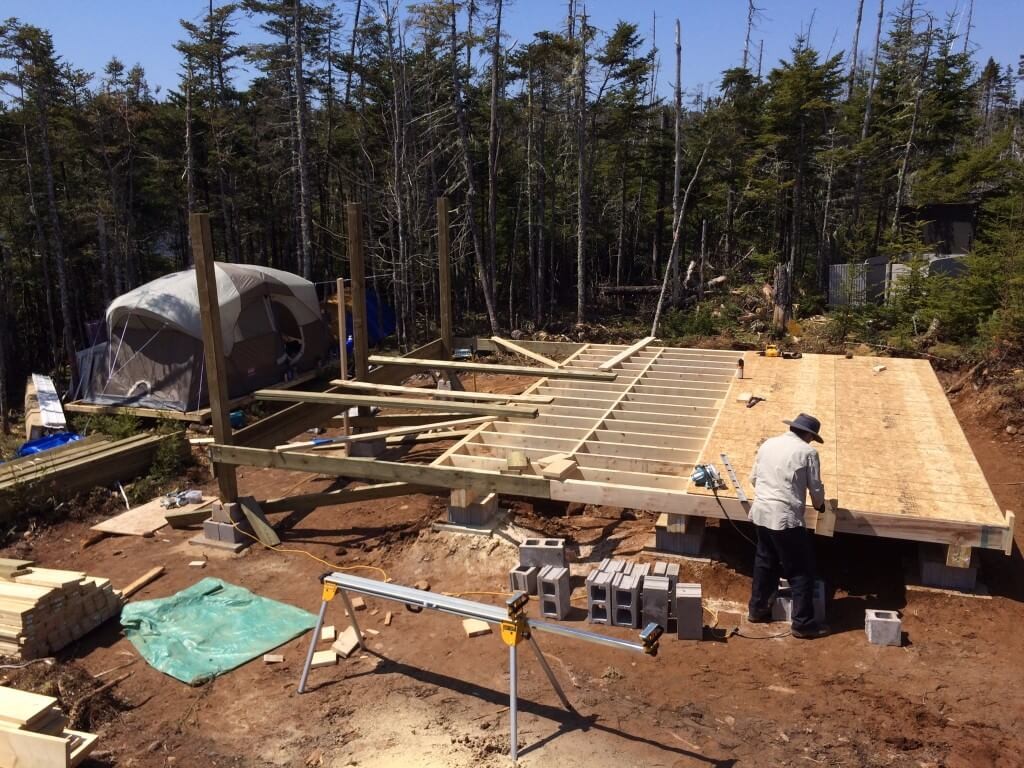 off grid cabin subfloor sheets being installed
