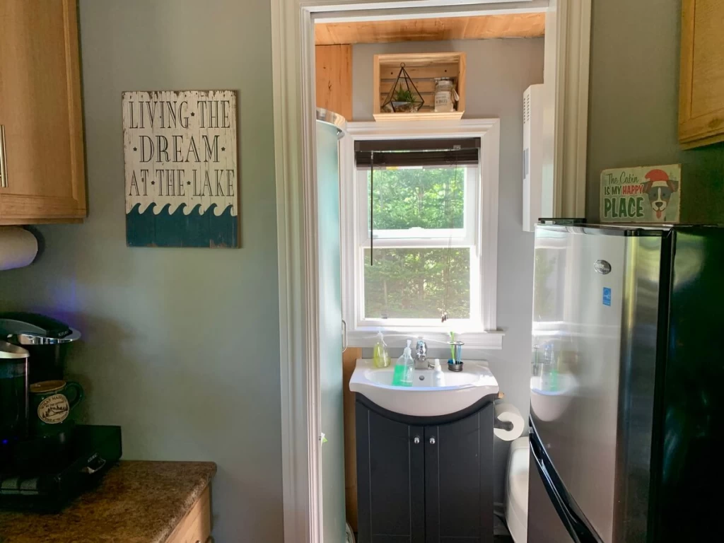 View from the cabin kitchen into the bathroom, showing the bathroom sink and compact layout