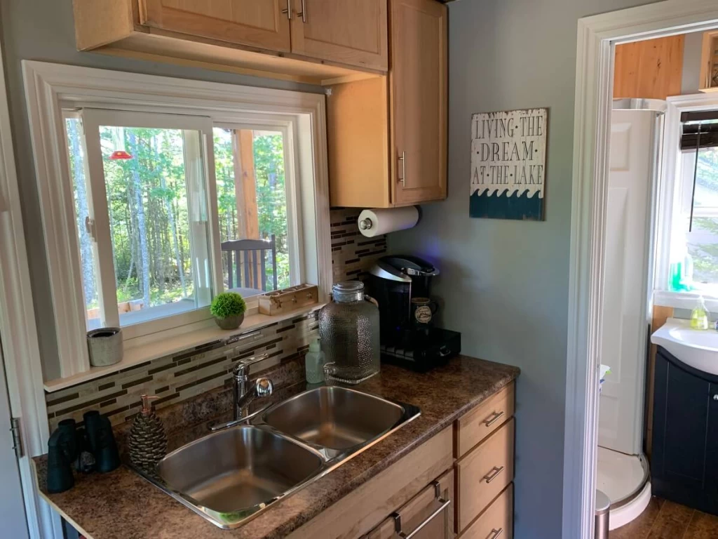 Double-basin kitchen sink in the off-grid cabin beside the bathroom doorway