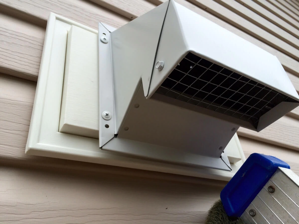 Metal exterior vent hood mounted on the cabin siding