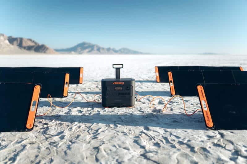 Jackery solar generator with six solar panels attached in a desert setting 