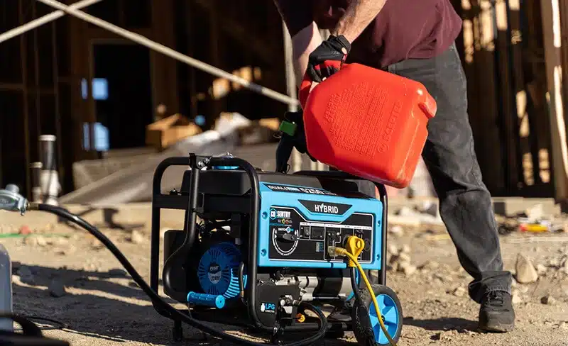 Image of man on a construction site refilling a generator with fuel