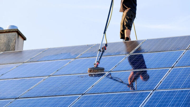 Cleaning solar panels with pole mounted brush